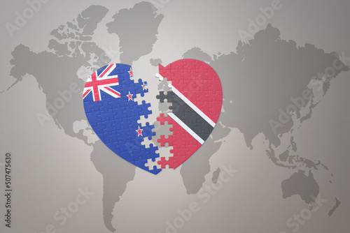 puzzle heart with the national flag of new zealand and trinidad and tobago on a world map background. Concept.