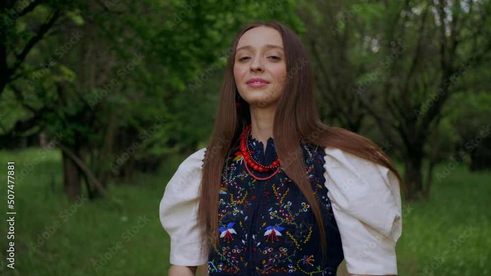 Ukrainian girl in a green garden. Beautiful woman in an embroidered dress walks in the park. Ukrainian girl in a green garden. Beautiful woman in an embroidered dress walks in the park.