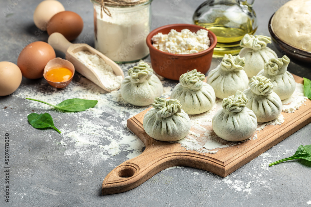 Khinkali with cheese and spinach. Raw semi-finished products dumplings. cooking khinkali. National Georgian cuisine. banner, menu, recipe place for text, top view Khinkali with cheese and spinach. Raw semi-finished products dumplings. cooking khinkali. National Georgian cuisine. banner, menu, recipe place for text, top view