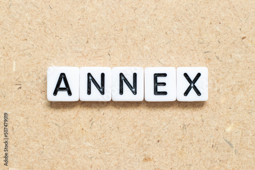 White tile alphabet letter with word annex on wood background photo