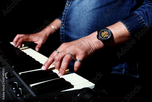 elderly man with long gray hair plays the keys. hands closeup