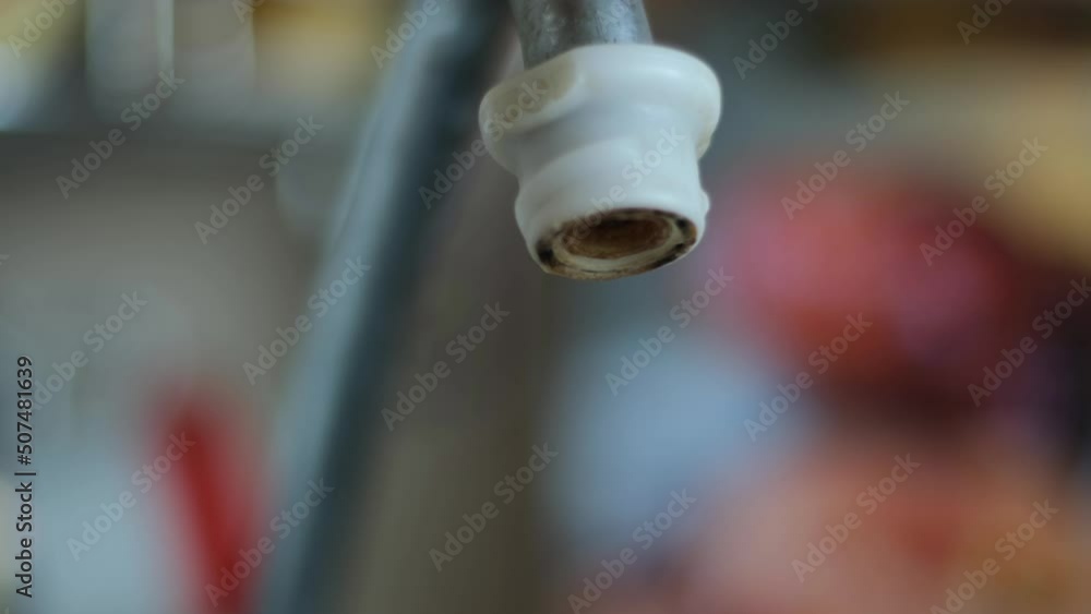  Leakage of water from a faucet, close-up view