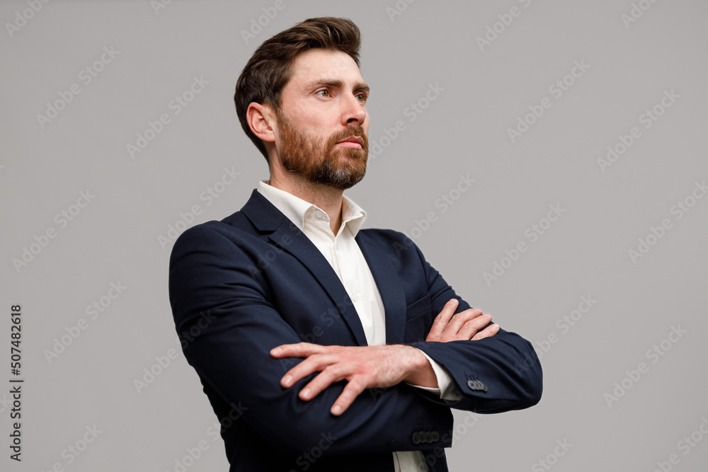 Serious business man in classic black suit with crossed hands looking at side Serious business man in classic black suit with crossed hands looking at side