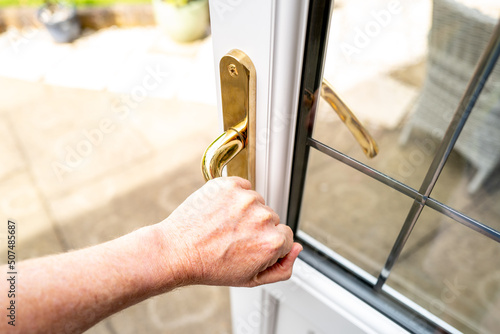 Fotografie Home owner seen opening a newly installed double glazed back door, leading to a patio area and rear garden