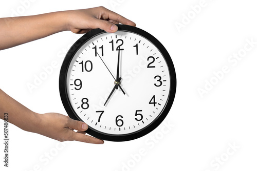 Hand holds a large black clock on a white background.