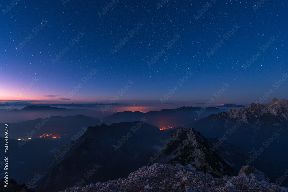 Sunset and stars at dusk in Julian alps mountain range. Serenity and friendship in the mountains.