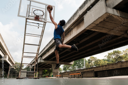 Two caucasian men pratice baskegball in court at urban street. photo