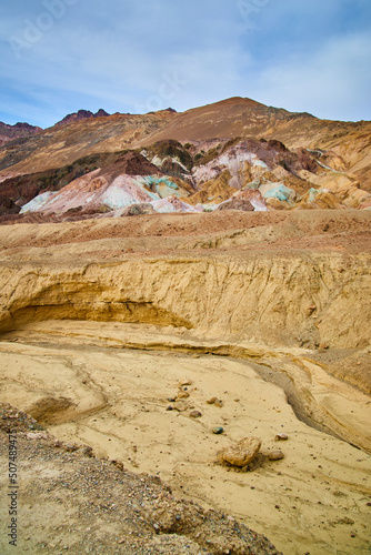 Desert creek dried up next to colorful mountains