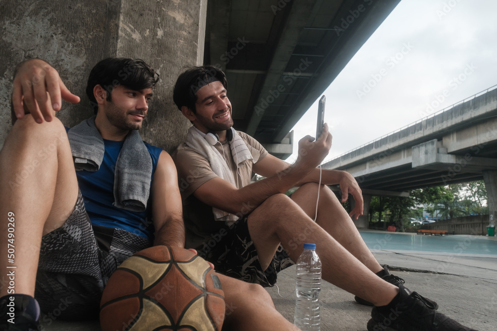 Two causian basketball player resting and ralax.