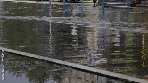 Town street flooded by heavy rain. Thunderstorm consequences. Car floating in puddles. Climate changes, adverse weather conditions, ecological traffic problem