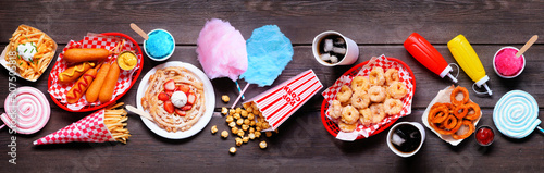 Fényképezés Carnival theme food table scene over a dark wood banner background