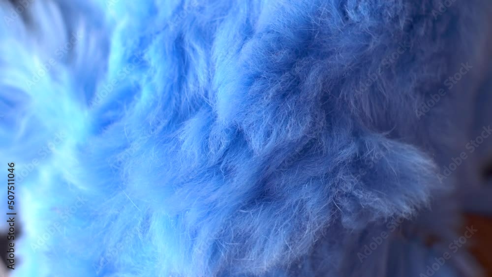 Blue faux fur. Long pile. Children's toy. Piece of clothing. Animal protection. Substitute for natural fur. Fabric production. Close-up. Object rotation. Blue faux fur. Long pile. Children's toy. Piece of clothing. Animal protection. Substitute for natural fur. Fabric production. Close-up. Object rotation.