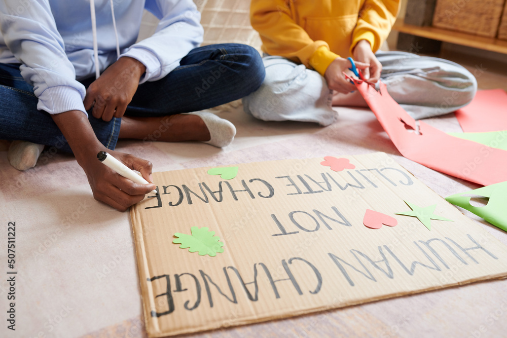 Girls decorating placard they made for climate change protest