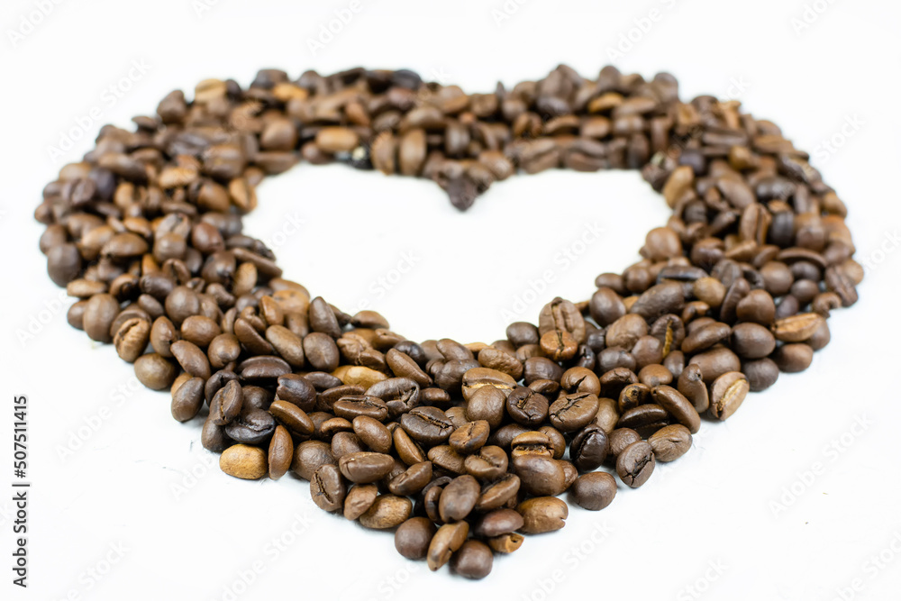 A heart made of roasted coffee beans on a gray (white) background. Place for the text (copy paste). Love of coffee. Good morning! A heart made of roasted coffee beans on a gray (white) background. Place for the text (copy paste). Love of coffee. Good morning!