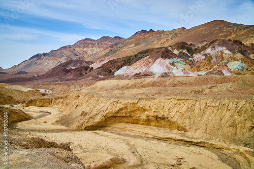 Dry desert creek next to Death Valley stunning colorful mountains