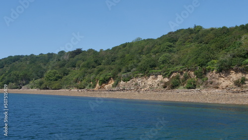 Fototapeta Naklejka Na Ścianę i Meble -  Sortie en bateau voilier - vue sur la côte avec de la nature, de la roche, du sable et de la mer, près de la rade de Brest, plage et forêt à proximité, région bretonne