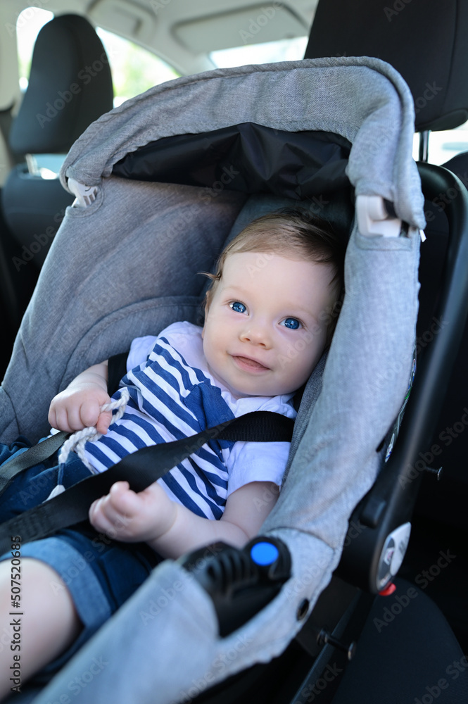 Cute baby in car child seat. Child transportation safety. Portrait