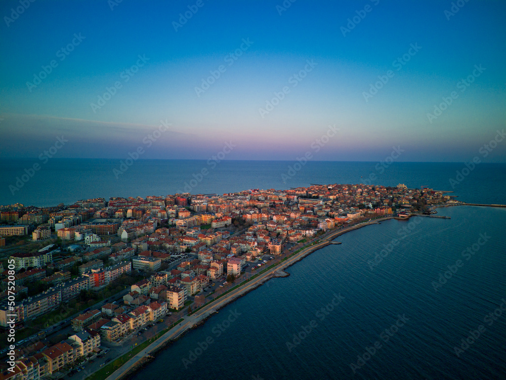 Fototapeta premium View from a height above the town of Pomorie with houses and streets washed by the Black Sea in Bulgaria