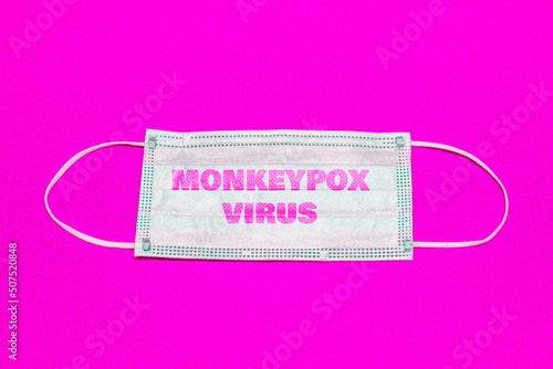 Monkeypox outbreak concept.Inscription monkeypox virus on medical face mask.Virus transmitted to humans from animals.Pink background.