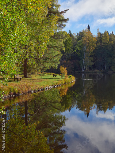 Joutsenlampi in Aulanko nature reserve and recreation area in Finnish city of Hameenlinna: autumn, colorful trees, reflection. photo