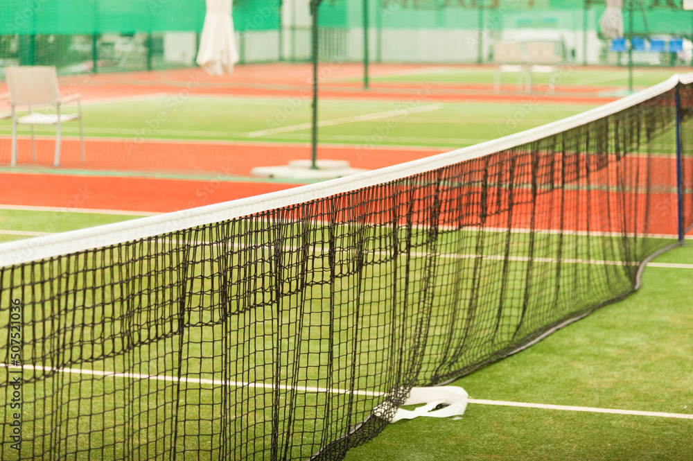 Fototapeta premium Tennis net on an empty tennis court. Horizontal frame with copy space