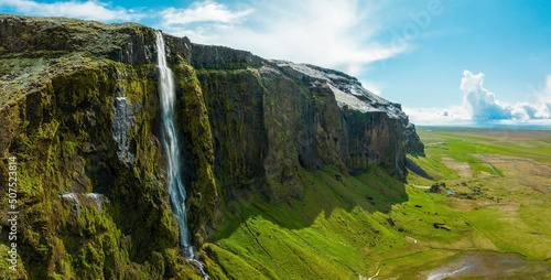 Beautiful Icelandic nature during summer time and sunny weather. Magical Iceland with green mountains, fields and waterfalls.