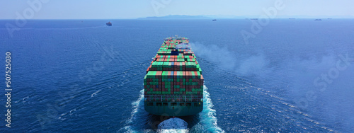 Aerial drone ultra wide photo of huge colourful truck size container tanker vessel cruising deep blue open ocean sea