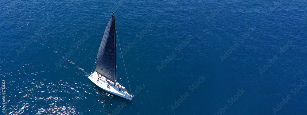 Aerial drone ultra wide panoramic photo of beautiful sail boat cruising deep blue Aegean sea