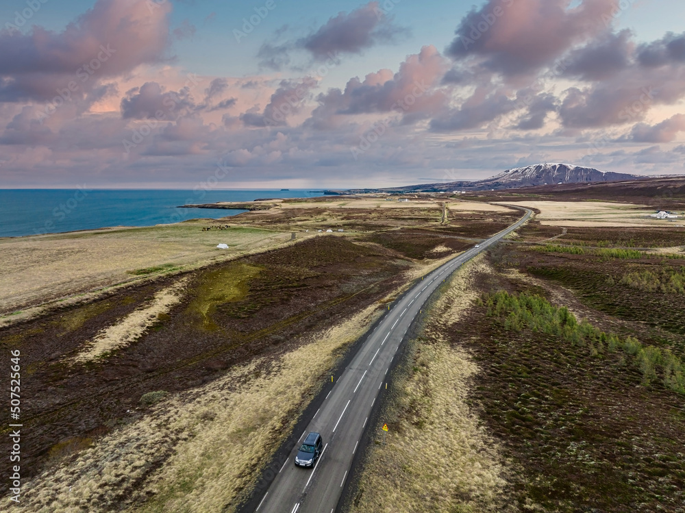 Endless road into the cloudy mountains and hills of Iceland during sunny cloudy weather. Aerial cinematic view. Endless road into the cloudy mountains and hills of Iceland during sunny cloudy weather. Aerial cinematic view.