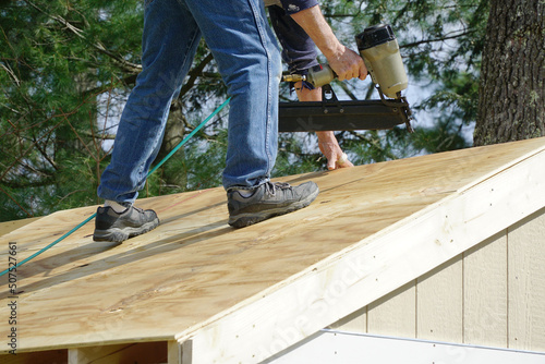 Wallpaper Mural handyman using nail gun to install shingle to repair roof Torontodigital.ca