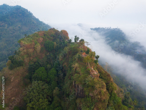 Hill which overgrown with dense of trees in the morning  with misty condition weather. The hill named Menoreh Hill, Central Java, Indonesia photo