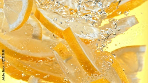 Super Slow Motion Shot of Fresh Lemon Slices Falling into Water Vortex at 1000 fps.