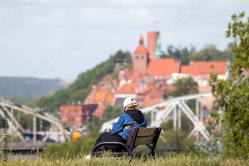 woman on the bench looking at the old city