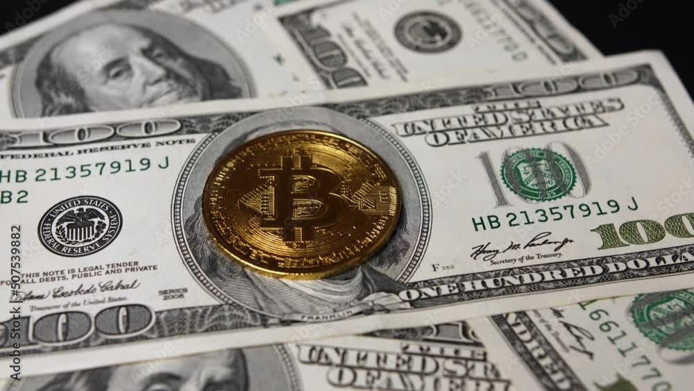 Close-up of dollar bills and bitcoins rotate. Cryptocurrency and American banknotes. Cash American money 100 dollars with a portrait of the president and bitcoins Close-up of dollar bills and bitcoins rotate. Cryptocurrency and American banknotes. Cash American money 100 dollars with a portrait of the president and bitcoins
