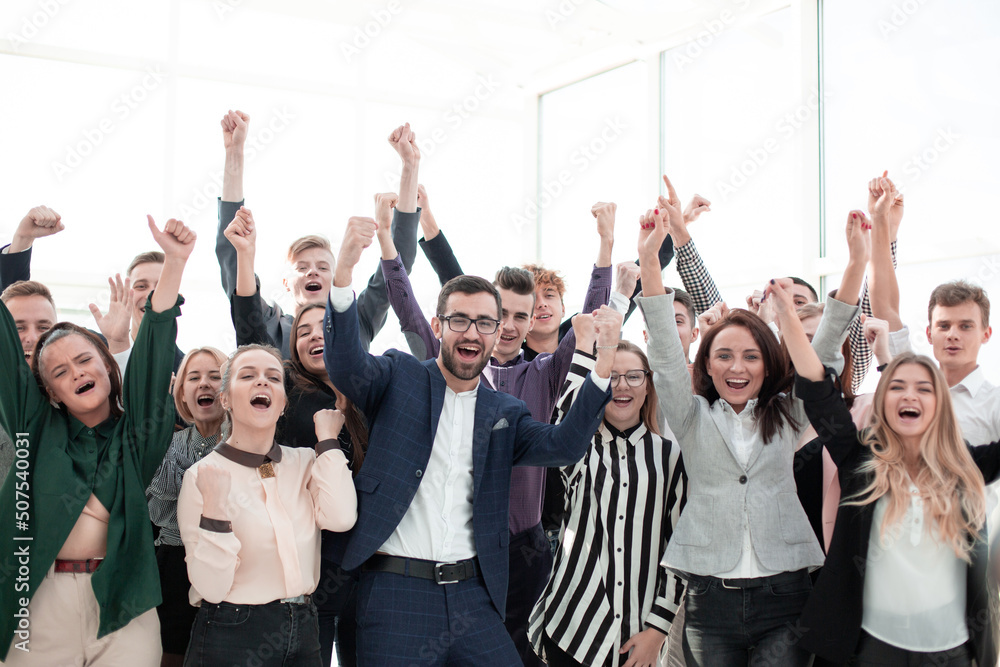 happy group of young employees with hands up