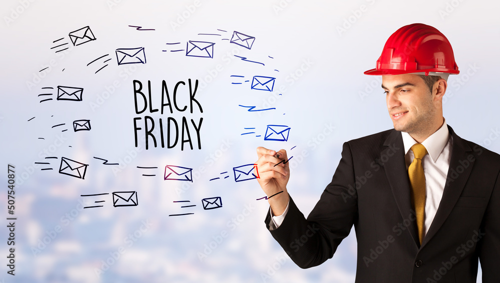 Young businessman with helmet drawing sale sign Young businessman with helmet drawing sale sign