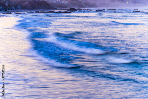 Waves at the beach at sunrise, sunset, shoreline