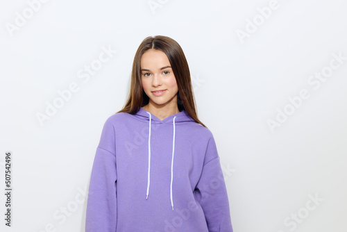 a calm woman stands on a white background in a purple tracksuit relaxing her body and smiling a little © Tatiana