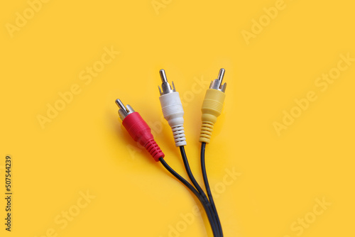 Audio and video cables on yellow background