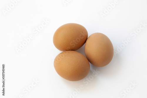 Three chicken eggs isolate on white background. Top view.