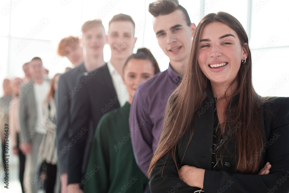 smiling young woman standing in front of a group of diverse young people