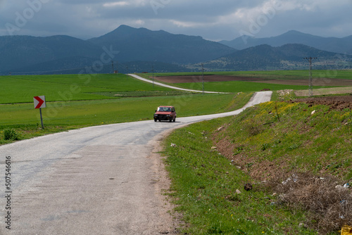A winding country road, and mountains in background.