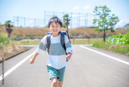Foto 走って学校に登校する小学生の男の子