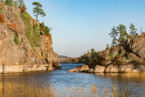 Pine trees on the cliffs of the lake at evening time.
