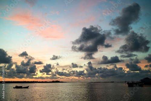 Sunset over the river. Silhouette of small boats at sunset. photo