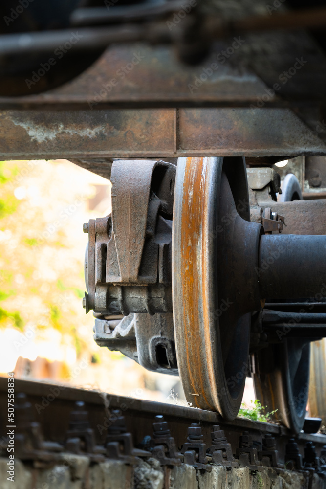 Closeup view of old rusty wheels of train. Railroad car chassis on rail. Freight transport concept. 