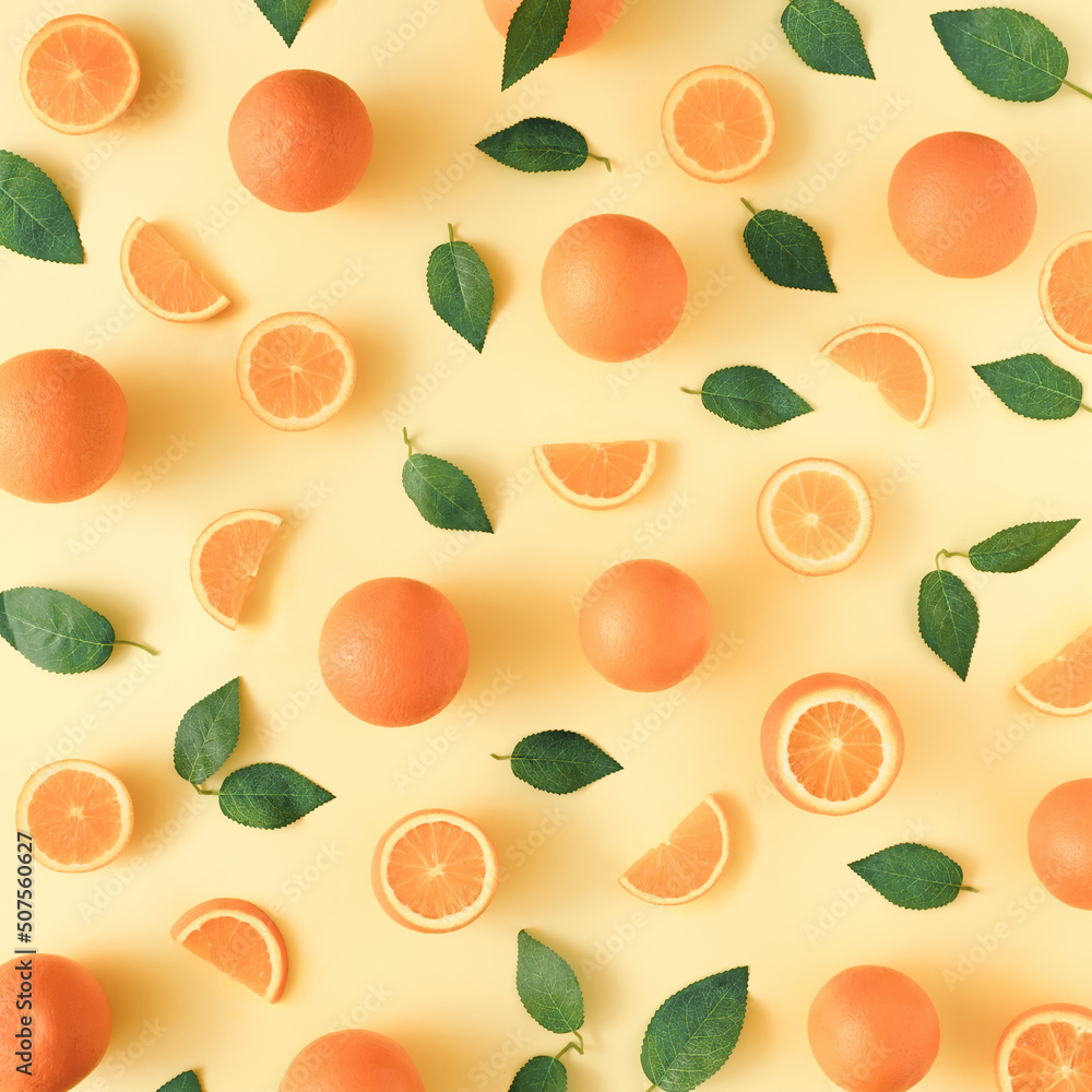Creative summer pattern made of oranges and green leaves on pastel yellow background. Fruit minimal concept. Flat lay. Creative summer pattern made of oranges and green leaves on pastel yellow background. Fruit minimal concept. Flat lay.
