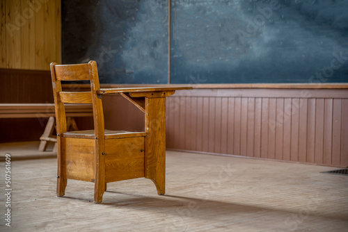 A single wooden desk in an abandoned, rural one-room schoolhouse on the prairies in Saskatchewan © Nancy Anderson