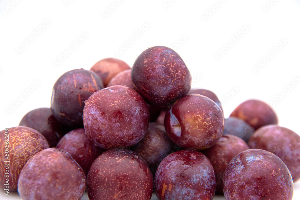 Purple plums on white background