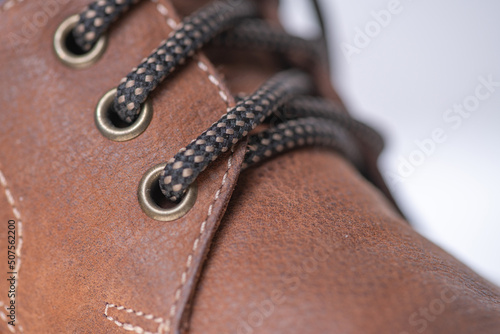 Fragment of fashionable men's brown winter boot made of genuine leather with fur.
